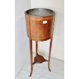 An Edwardian mahogany inlaid jardiniere stand with a liner over splayed legs,