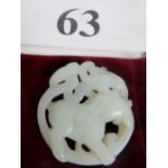 A white carved jade pendant with an elep