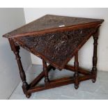 A c1900 carved oak drop leaf corner tabl