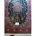 A mid-late 20th century part silk Pakistan rug on green ground,