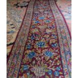 A fine late 19th/20th century runner on Burgundy field and flower design, 447cm x 54 cm approx,