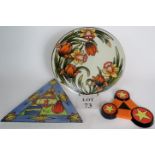 A Lorna Bailey charger decorated with daffodils, a 'Space Station' wall plaque,