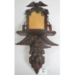 A profusely carved bracket mirror with eagles and acorns, original glass,