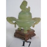 A Chinese carved jade pot and cover, with Shi Shi finial, twin mask and drop ring handles,