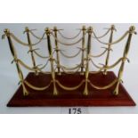 A brass wine bottle rack on mahogany plinth base,