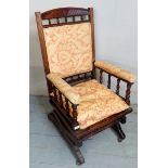 A Victorian mahogany framed rocking chair with upholstered back seat and arms and with loose seat