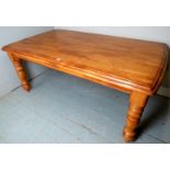 A 20th century oak dining table with a planked top over turned legs in clean condition,