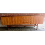 A large 1960's teak G-Plan sideboard with 4 small drawers flanked by double cupboard doors to one