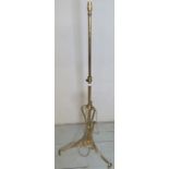 A decorative brass standard lamp with an adjustable column,