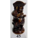 A 19th century treacle glazed pottery `Snuff taking` Toby jug, 24cm high, (a/f),