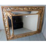 A 19th century gilt wood ornate wall mirror with a central mirror flanked on 4 sides by small