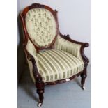 A Victorian mahogany show wood framed carved armchair upholstered in a green stripe silk material,