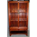 A large Chinese showwood pantry cupboard with spindle construction to sides and doors, H70.