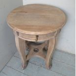 A small 20th century pale limed round occasional table with a drawer,