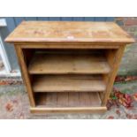 A late 19th century pine open bookcase with two shelves, (slightly a/f),