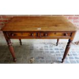 A Victorian mahogany writing table with two small drawers over turned legs,