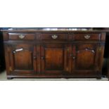 A 20th century oak sideboard with 3 small drawers over 3 cupboard doors to base,
