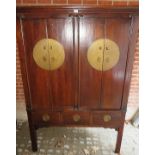 A large 20th century Chinese 4 door cupboard with central brass lock plates over 3 small drawers,