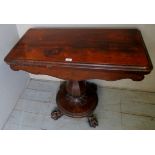 A Victorian rosewood turnover card table with a green circular biaze over an ornate column and claw