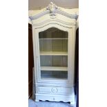 A 20th century white armoire with a single glazed door over a drawer to base,