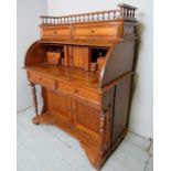 A Victorian design tambour fronted cylinder desk with a soldiered gallery rail above a filled