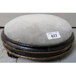 A small Victorian ebonised round foot stool with gold detailing,