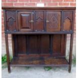 A rustic 17th century style oak cabinet with double panelled cupboard doors over a large open shelf