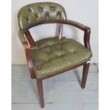 A 20th century Captain's desk chair upholstered in green button backed leather,