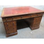 A Victorian mahogany Partner's desk with a red leather top over drawers and cupboards to both sides,