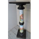 An ornate ceramic and ebonised torchere stand depicting classical scenes,