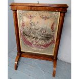 A Victorian walnut pull up fire screen with a tapestry panel depicting a werewolf,