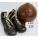 An old lace up football and a pair of bl