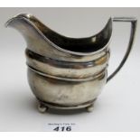 A Georgian silver cream jug on ball feet