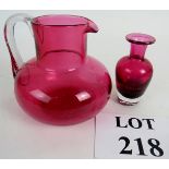 Two items of cranberry glass, an attractive squat jug with clear handle,