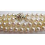 A double strand pearl necklace with diamond clasp, approx 18" long, boxed,