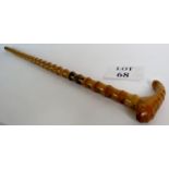 A carved walking stick with a faux bamboo pattern to the shaft,
