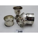 A collection of three silver napkin rings, all fully hallmarked and a silver hallmarked egg cup,