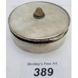 A silver circular box with mirror and having a mother of pearl lid, with inset semi-precious stone,