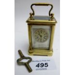 A miniature carriage clock with decorated enamel panels of cherubs, and key,