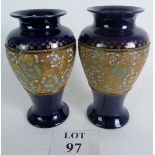 A pair of Royal Doulton vases with enamelled and gilt decoration over a dark blue ground, 26.