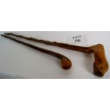 A pair of natural form walking sticks, one with a root wood style handle, both with brass ferrules,