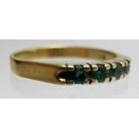 An 18ct gold ring set with four emeralds, size P,