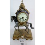 A reproduction mantle clock with a circular dial mounted on a horse standing on a brass pedestal