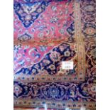 A fine 20th century Persian carpet on claret ground with blue patterned border,