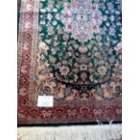 A mid-late 20th century part silk Pakistan rug on green ground,