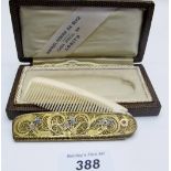A comb with an elaborate case of filigree and flower enamelling, in original box,