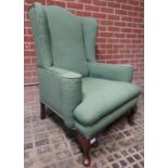 A 20th century mahogany framed wingback armchair upholstered in green material and in good clean