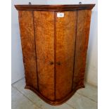 A pretty 19th century figured walnut hanging corner cabinet with shaped double doors, slightly a/f,