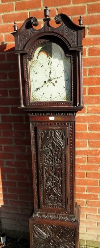 A 19th century carved oak 8 day longcase clock with painted arched moon phase dial and complete