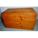 A large stripped pine trunk with a fitted interior and iron carry handles,